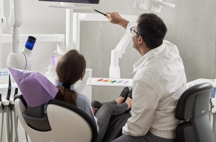A dentist reviewing a digital dental radiograph on screen